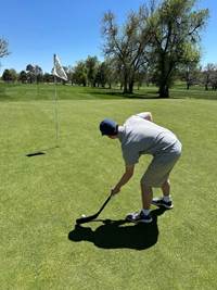 A person playing golf on a golf course

AI-generated content may be incorrect.